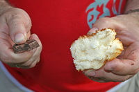 Trozo de chocolatre y bollo en manos de un asistente