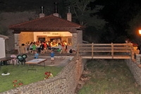 Asador lleno de comensales, degustando la cena