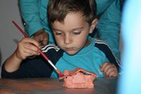 Niño pintando su casa para insectos