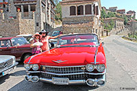 Dos elegantes damas junto al Cadillac rojo
