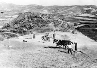 Foto de jaloneros y jaloneras en la era junto a El Calvario, trillando