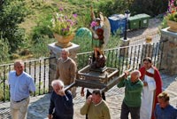 Grupo de personas portando las andas con San Miguel, camino de la iglesia