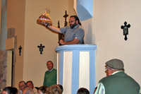 Subastador con una tarta, subastando desde el púlpito de la iglesia