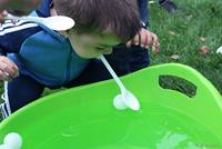 Niño pescando con una cuchara en la boca, una bola en el agua
