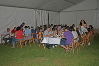 Comensales de la cena popular ubicada en la carpa del parque