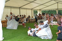 Tres personas en un saco intentando saltar y avanzar